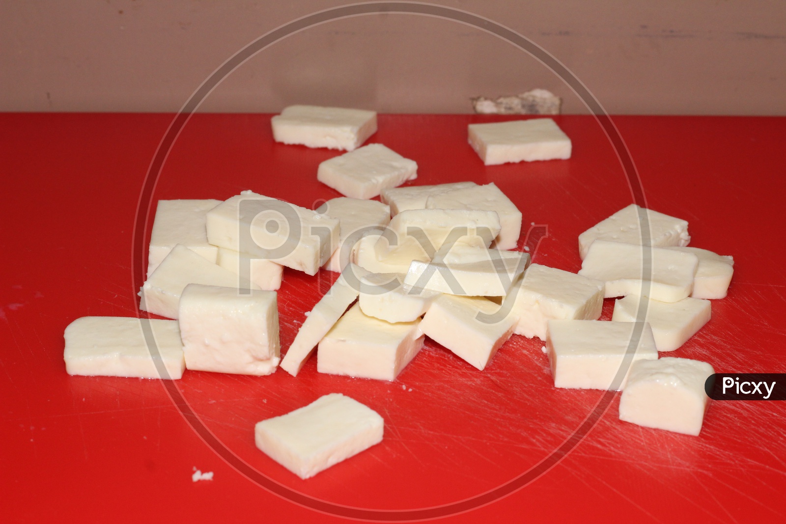 Image of Freshly Chopped Paneer Pieces on a Cutting Table-LK443669-Picxy