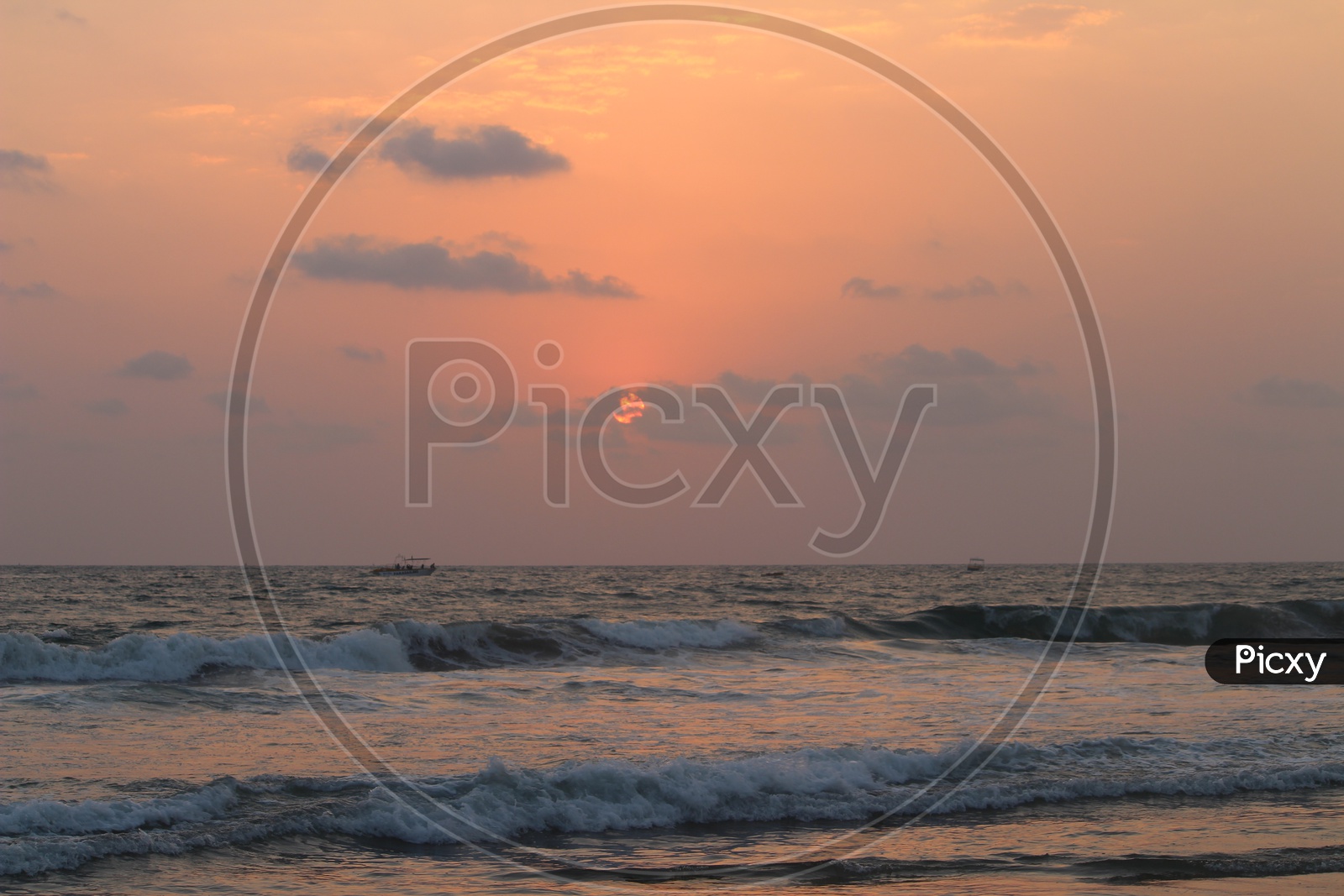 Sunset Over a Beach With bright Sun And Waves Striking Shore