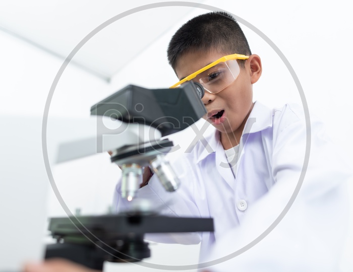 Excited Boy Using Microscope In a Laboratory wearing White Apron