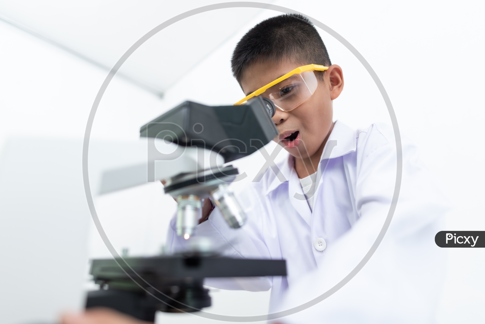 Excited Boy Using Microscope In a Laboratory wearing White Apron