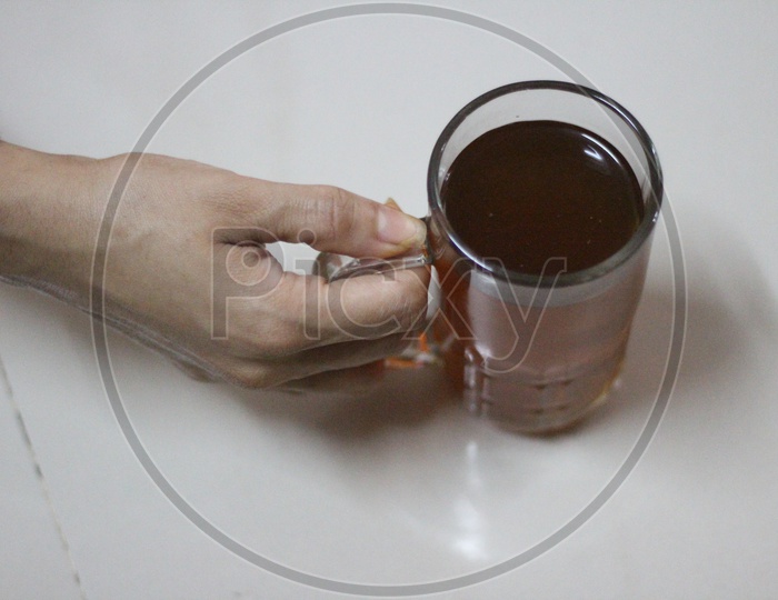 Indian Woman Hand Holding Lemon Tea  in a Glassware Cup On an isolated White Background