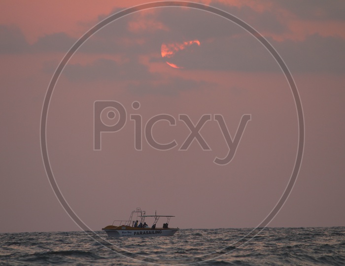 Tourists Boats in Sea With Sunset Sky In Background