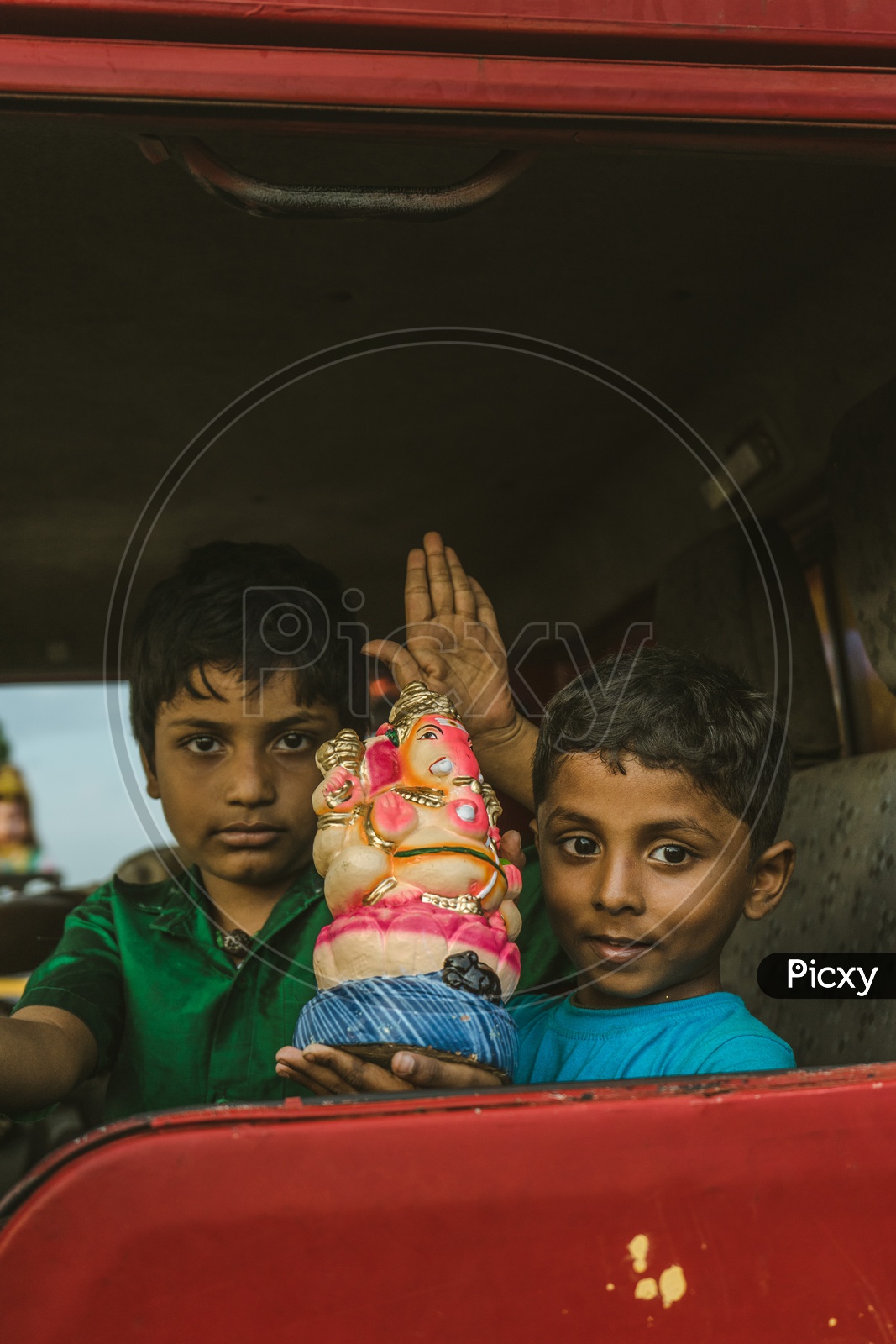 Two kids with clay ganesha on their way to nimarjan
