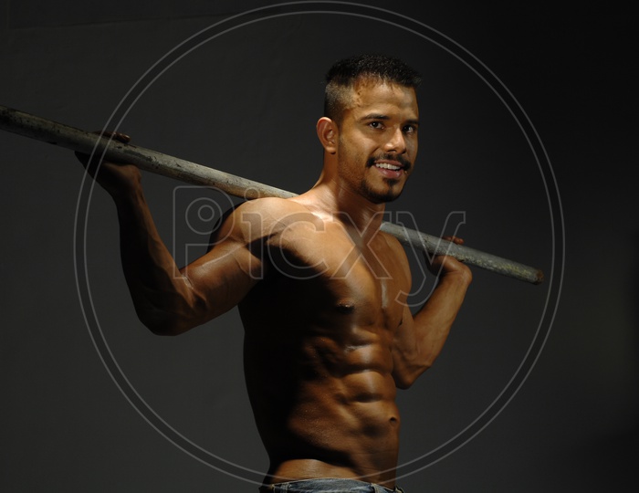 Indian Muscular Man holding an iron rod