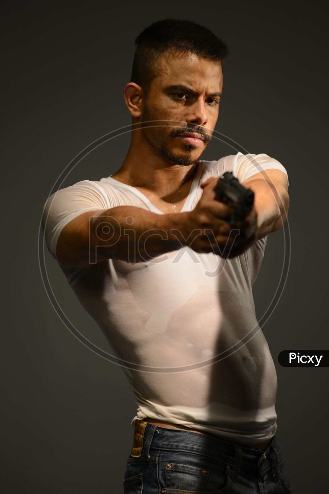 Indian Muscular Man aiming with a pistol