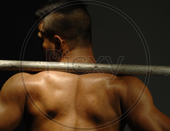 Indian Muscular Man flexing his back with undercut hairstyle