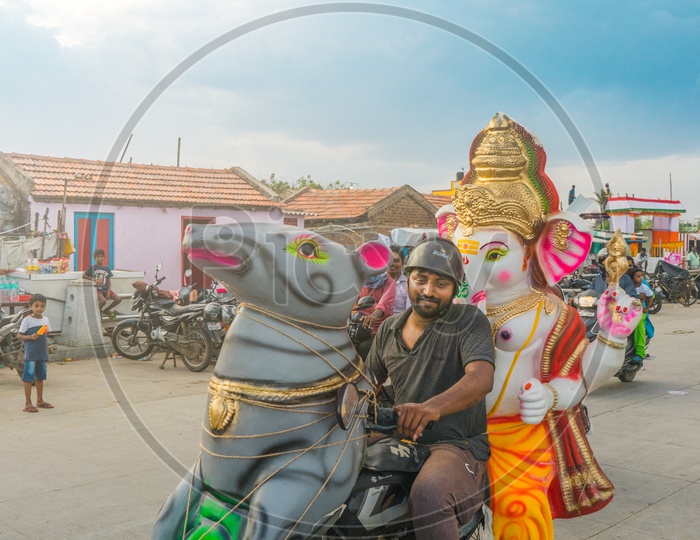 A person carrying ganesha idol on his motorcycle