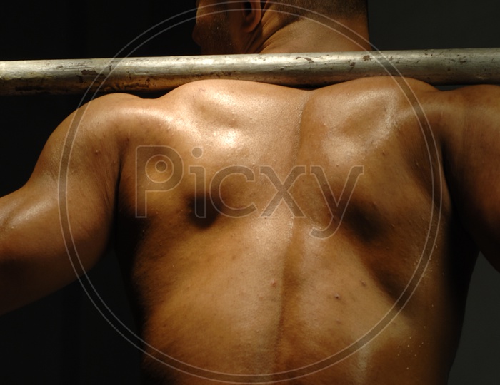 Indian Muscular Man flexing his back muscles