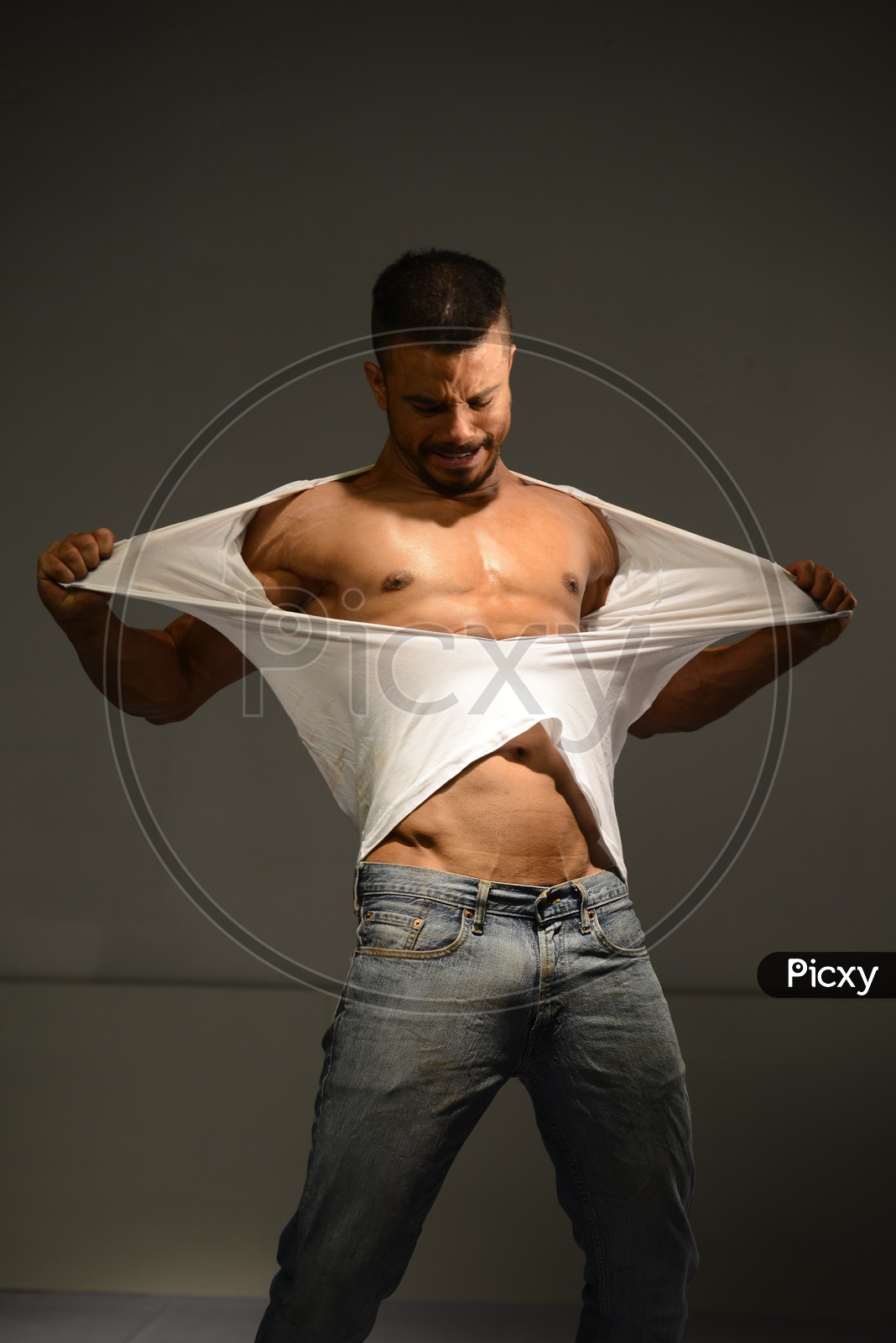 Indian Muscular Man tearing his vest into pieces