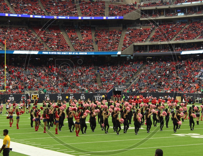 Both teams cheerleaders performing in the stadium
