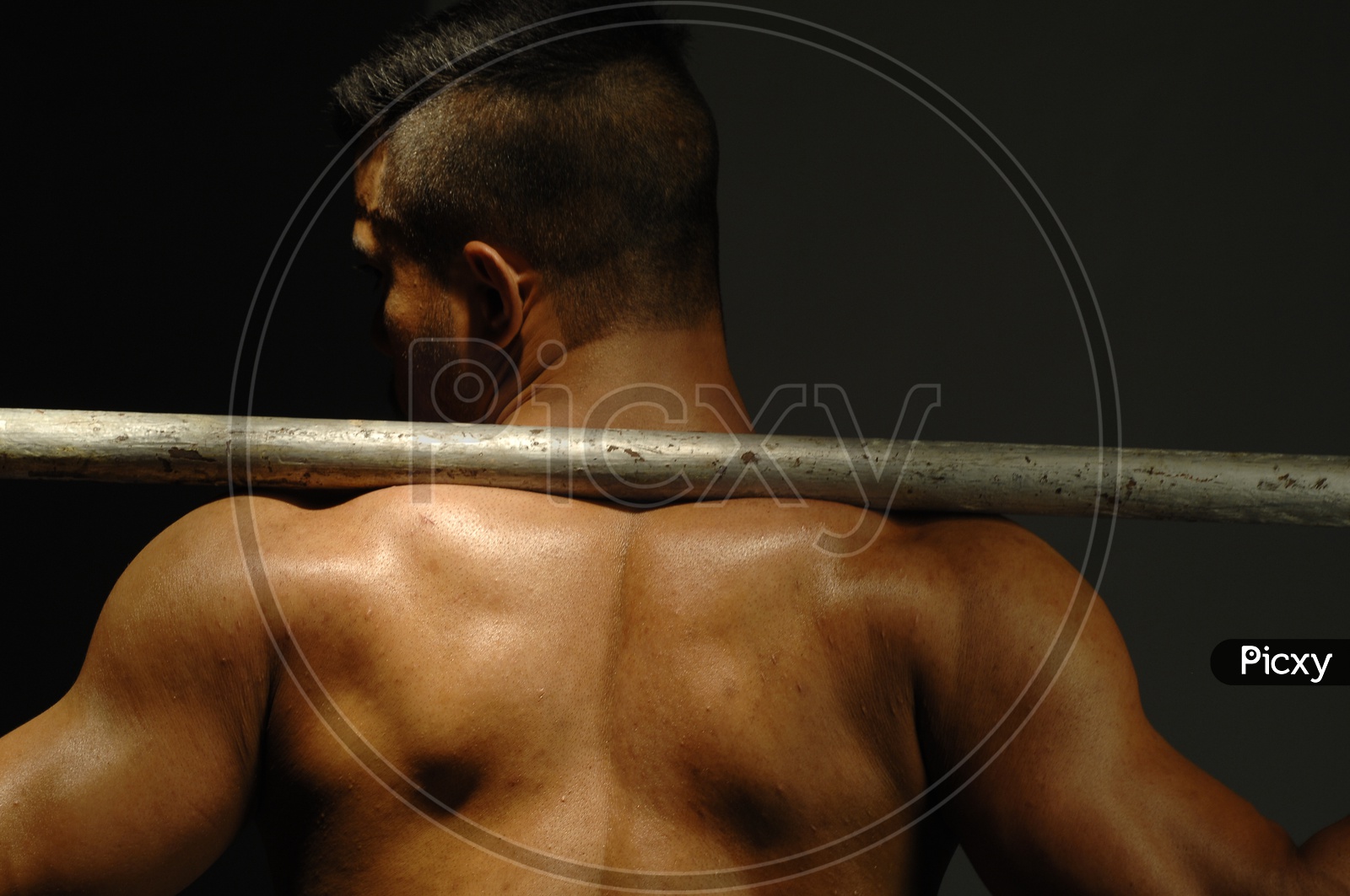 Indian Muscular Man flexing his back with undercut hairstyle