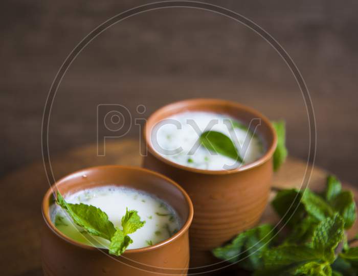 Summer Cooler Drink  Buttermilk  Made Of Yogurt And Spice Herbs Over a  Wooden Background