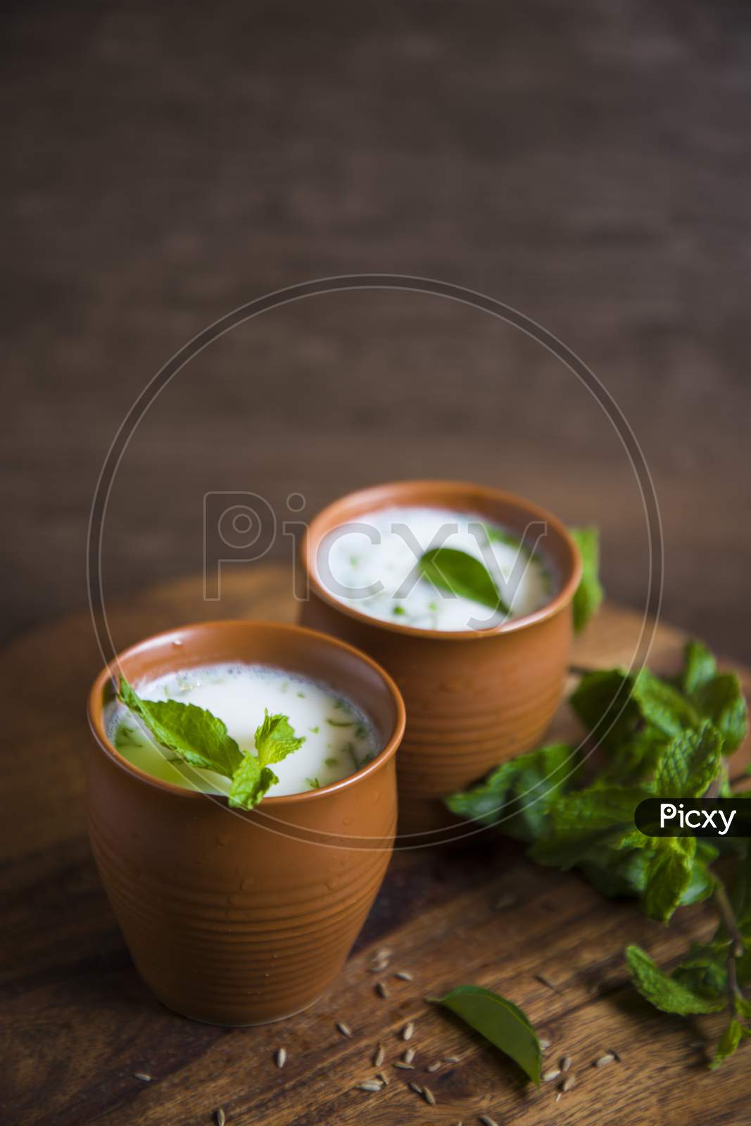 Summer Cooler Drink  Buttermilk  Made Of Yogurt And Spice Herbs Over a  Wooden Background