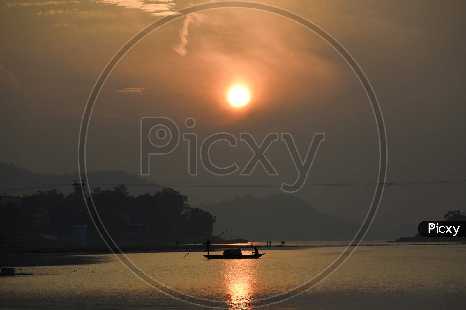 Fisherman Paddle A Boat After Fish In The Brahmaputra River, In Guwahati