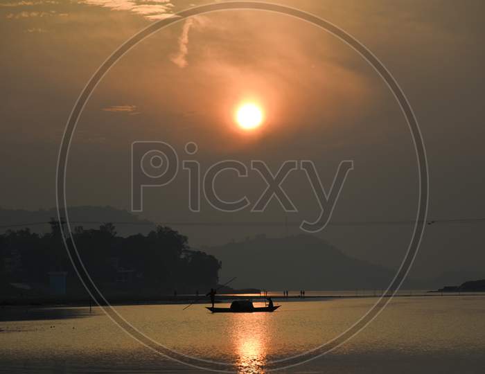 Fisherman Paddle A Boat After Fish In The Brahmaputra River, In Guwahati
