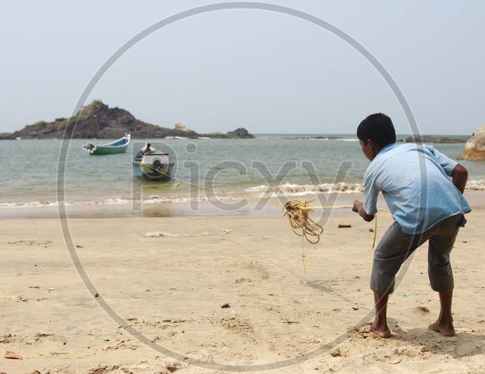 A Boy pulling the boat rope