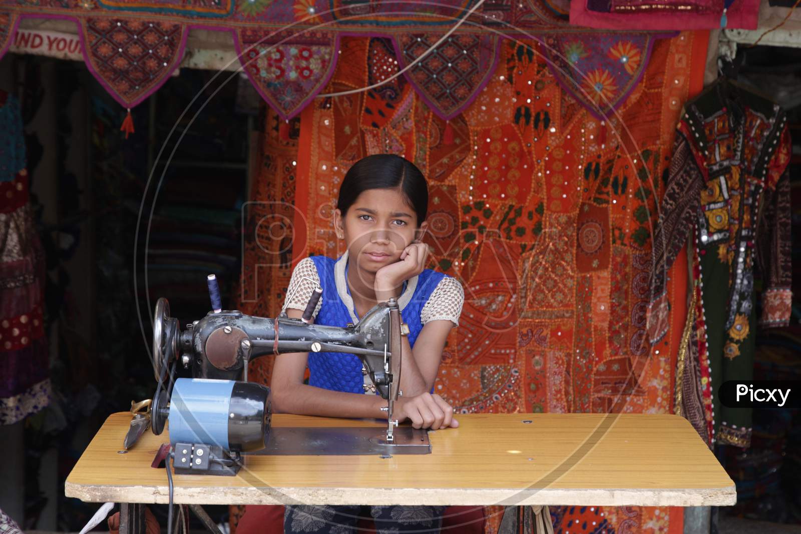 Indian Girl Sitting At A Sewing Machine in Jaisalmer Rajasthan
