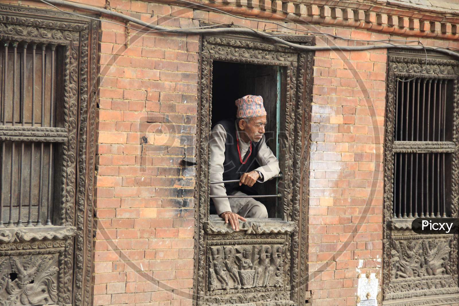 Old Nepalese Man Looking through a Window