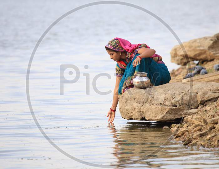 A Rajasthani Woman Collecting  Water For Pooja  From Gadisar Lake  In Jaisalmer, Rajasthan