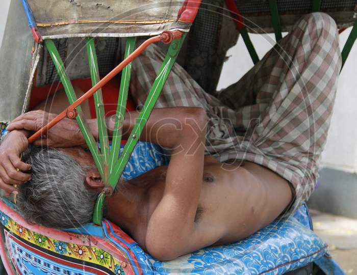 Indian Elderly Man sleeping in a Rickshaw