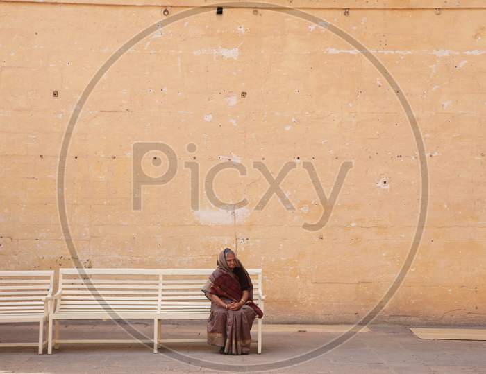 Indian elderly woman sitting on the bench alone