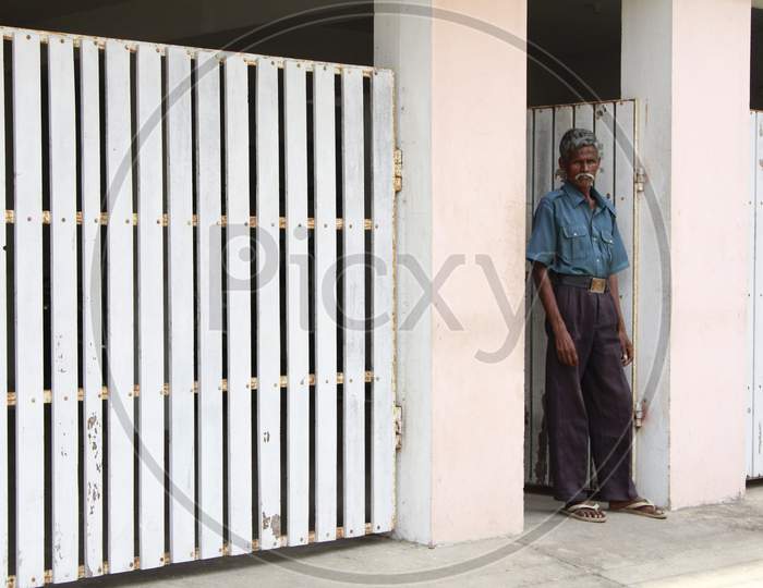 A Watchman standing by the wooden gate