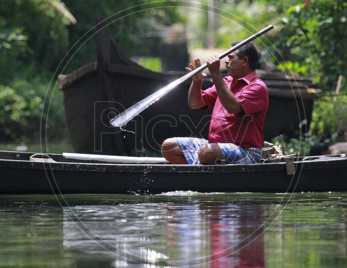 Indian Man Rowing the Boat in Kerala