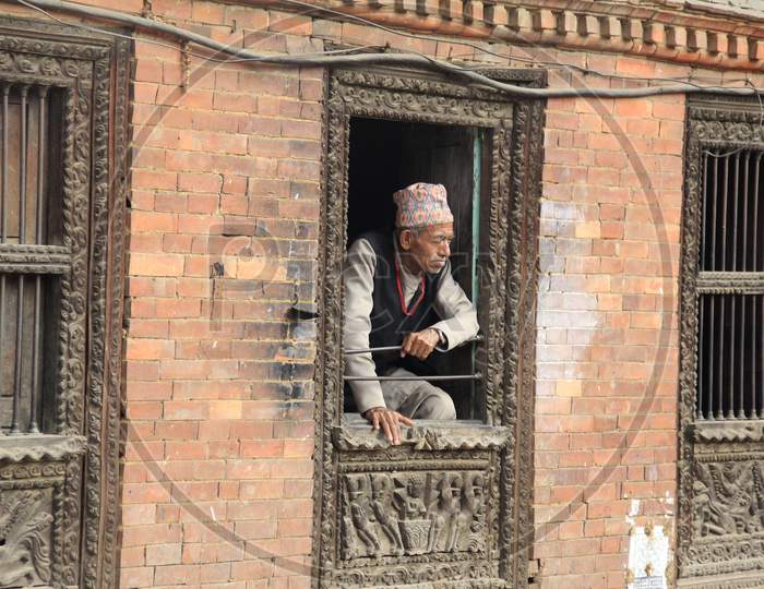 Old Nepalese Man Looking through a Window