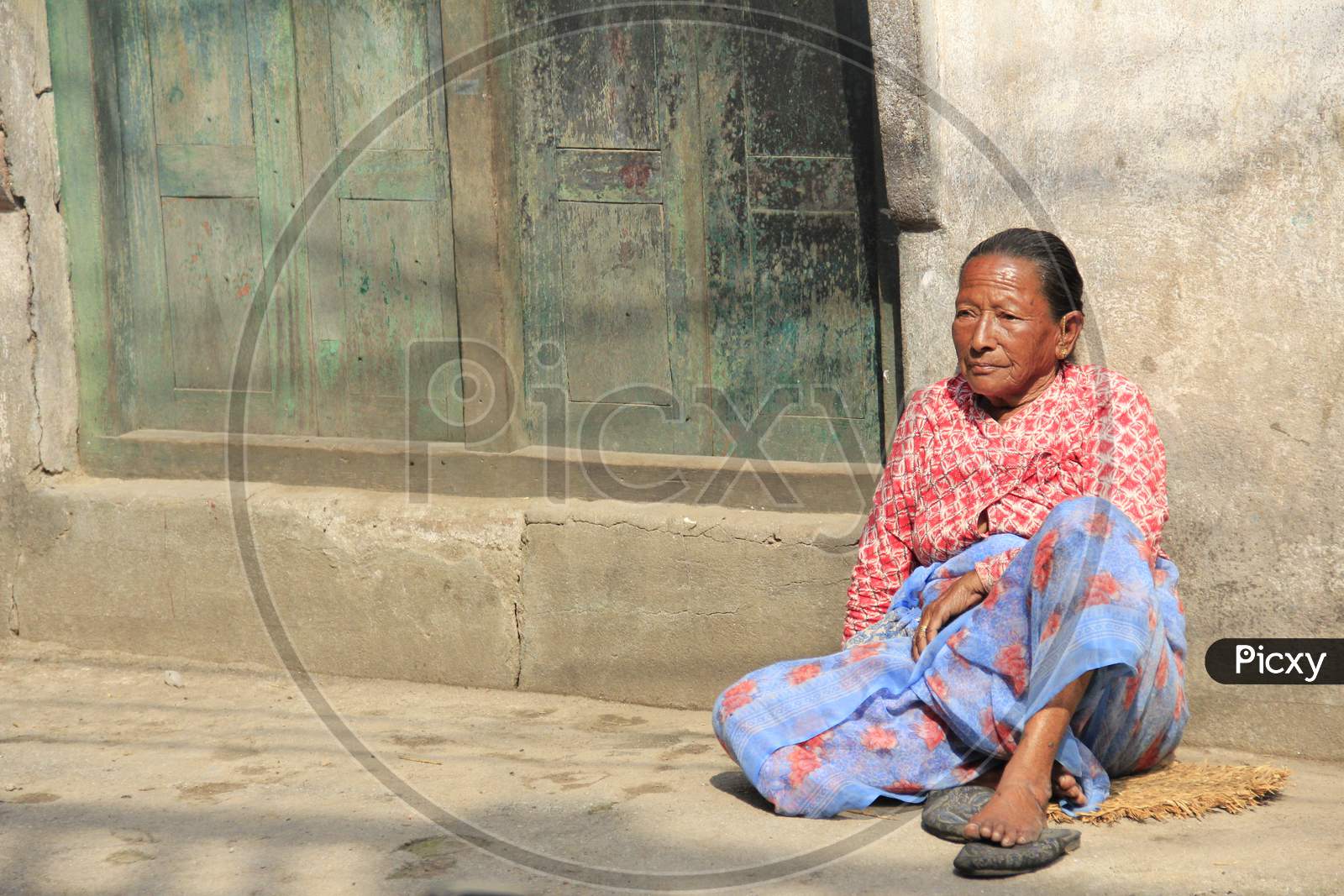 Old Nepalese Woman sat outside her house