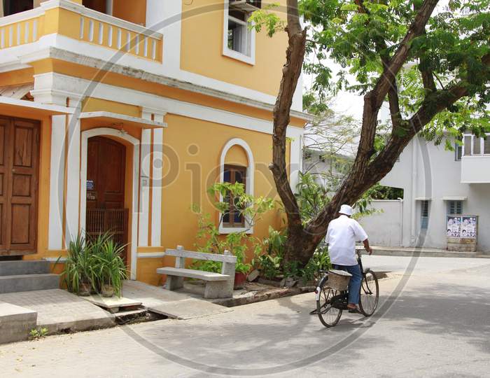 Indian Man riding bicycles through the streets of Pondicherry