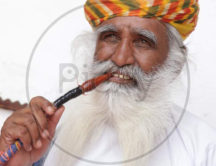 Indian Old man with Hookah pipe in his mouth