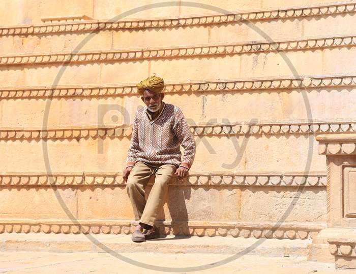 Indian Elderly man sitting on the steps