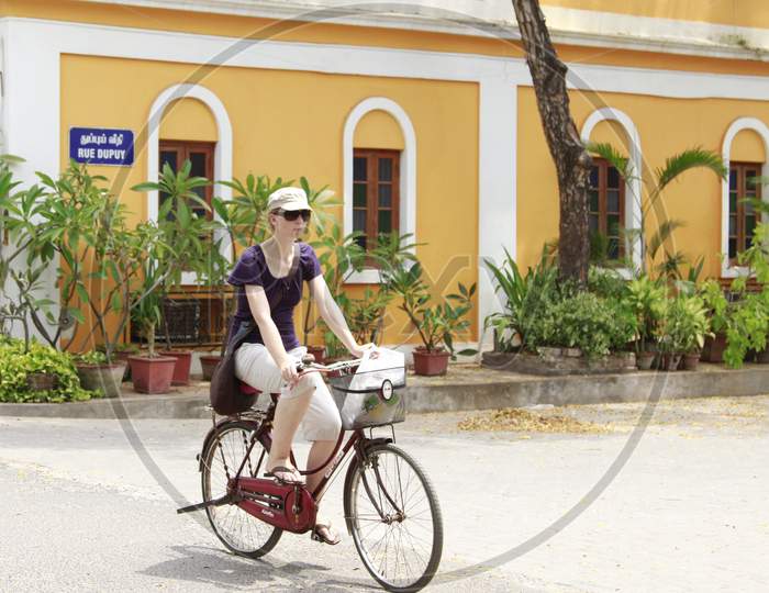 Foreign woman riding bicycle through the streets of Pondicherry