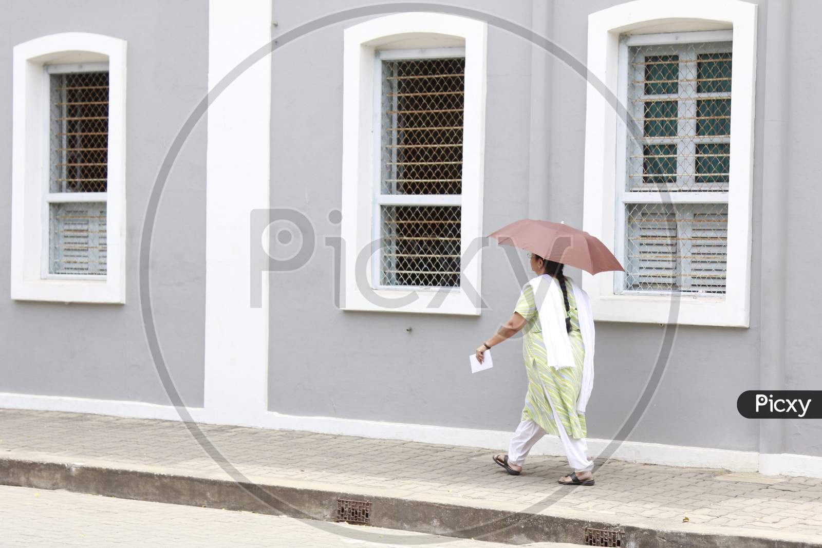 A Woman walking with an umbrella