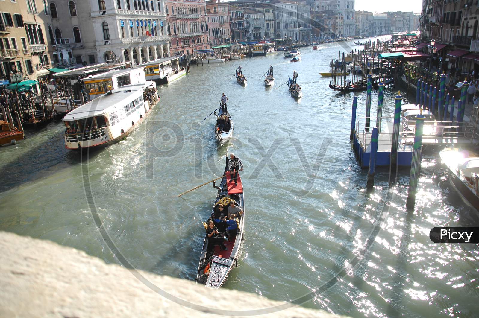 Tourists enjoying the gondola boat rides through the Grand canal