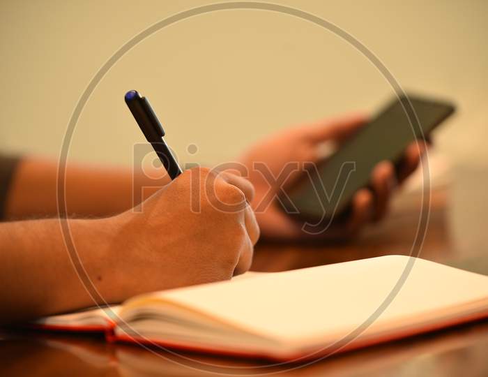 a man taking down notes from a mobile phone