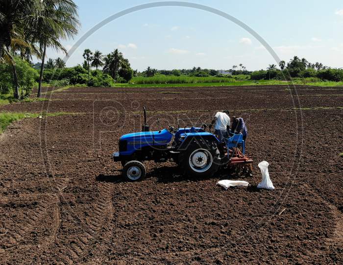 A Farmer Ploughing Agricultural Land With Tractor