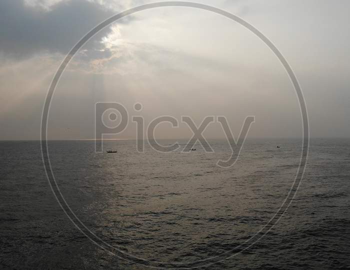 Silhouette Of Fishing Boat On Sea With Sky As background