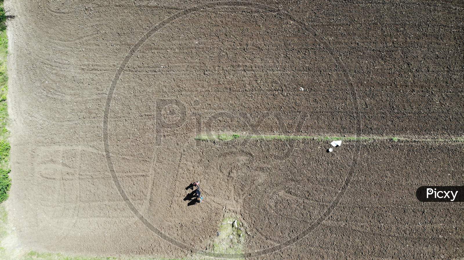 Drone Shot Of  A Farmer Ploughing Agricultural Land With Tractor