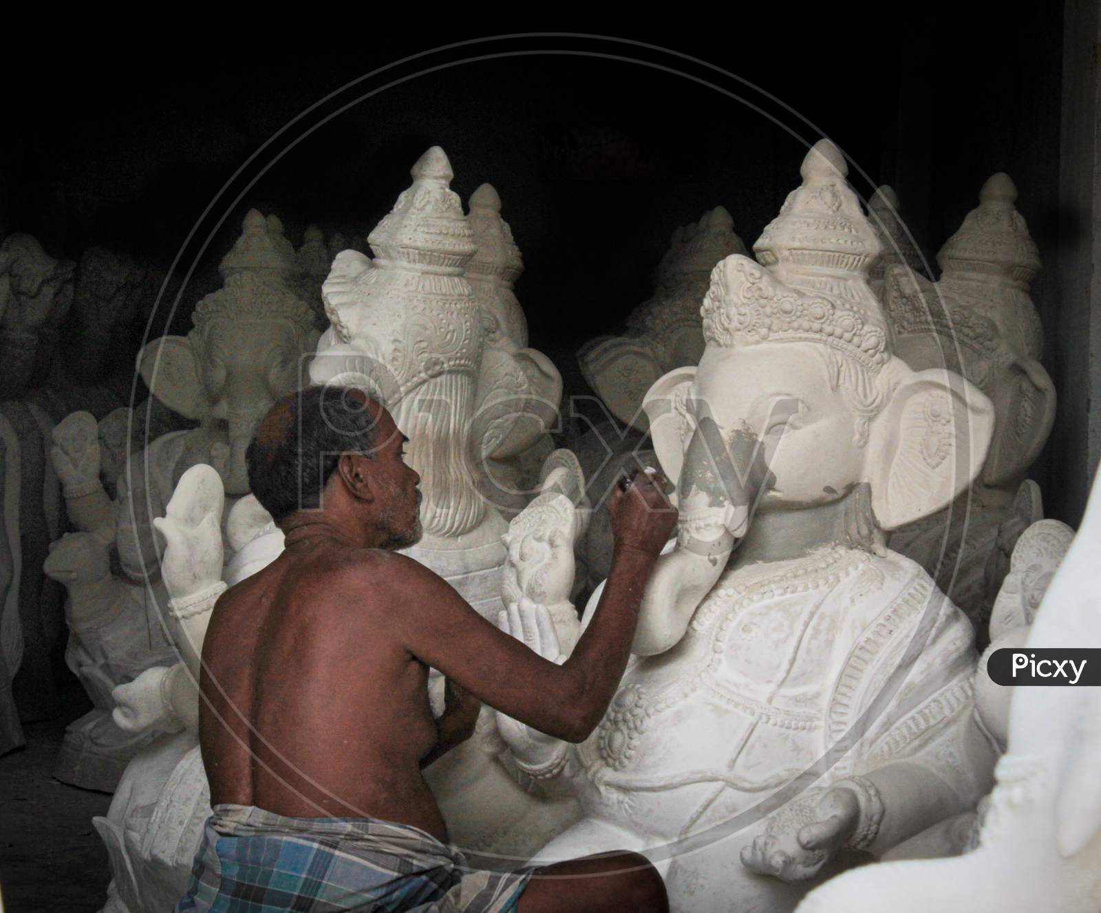 A man working in making of idols