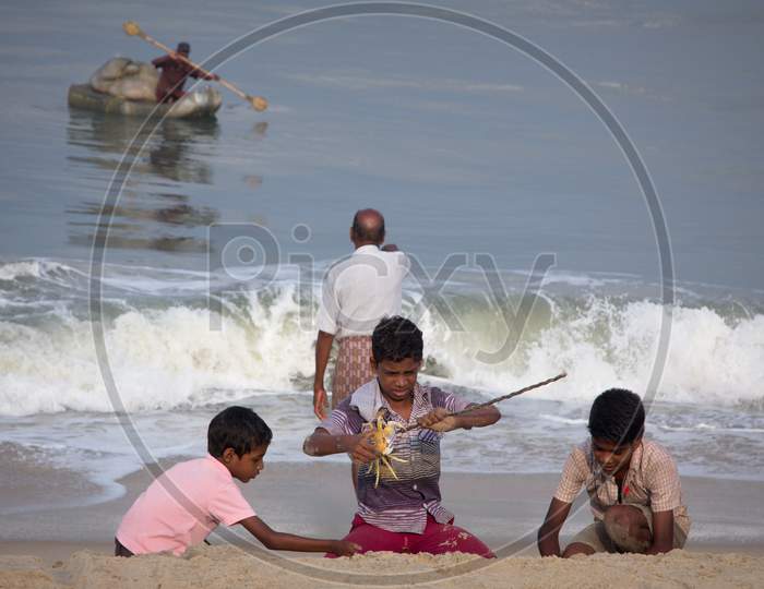 Indian Kids Playing with Crab at Marari Beach, Kerala
