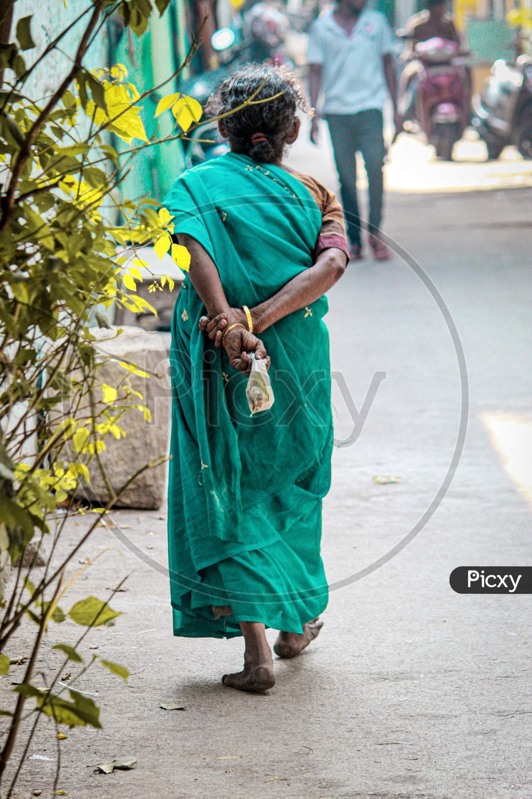 An Elderly Woman Walking on The Streets