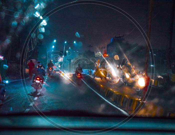 A View Of Bikes Moving On Road From  A Car Glass Shield