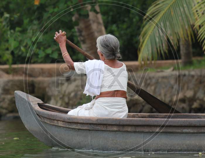 Indian Old Woman Roving a Boat in Kerala