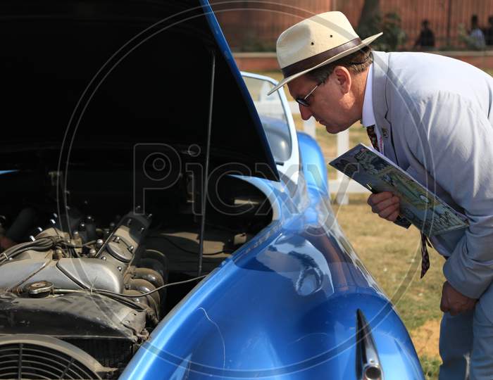 A Man inspecting the Car Engine