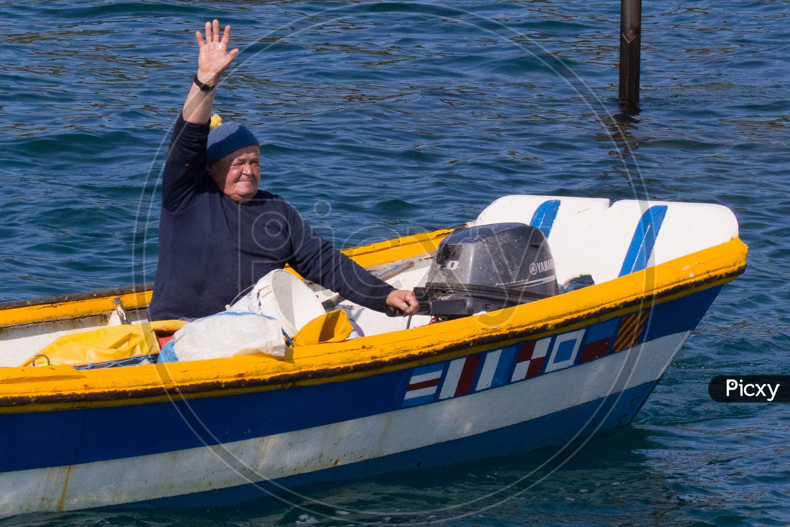 An Old Man Driving a Motor Boat in Chausey, Normandy, France