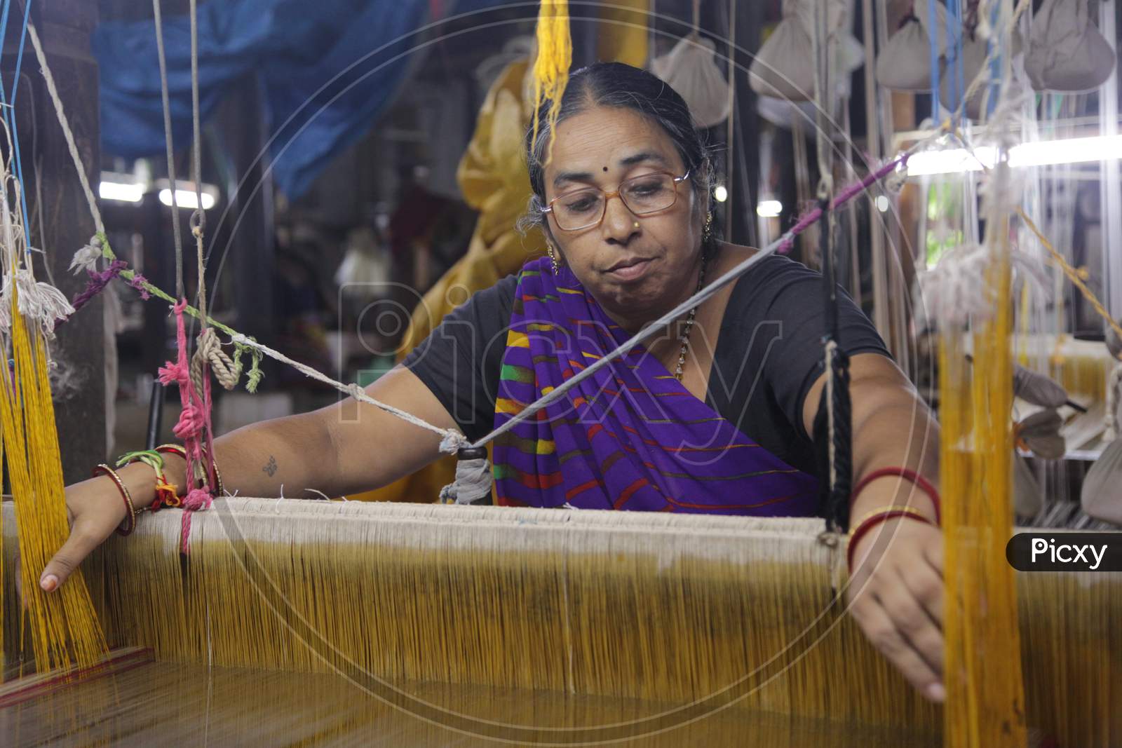 Indian Woman coloring the weaving thread