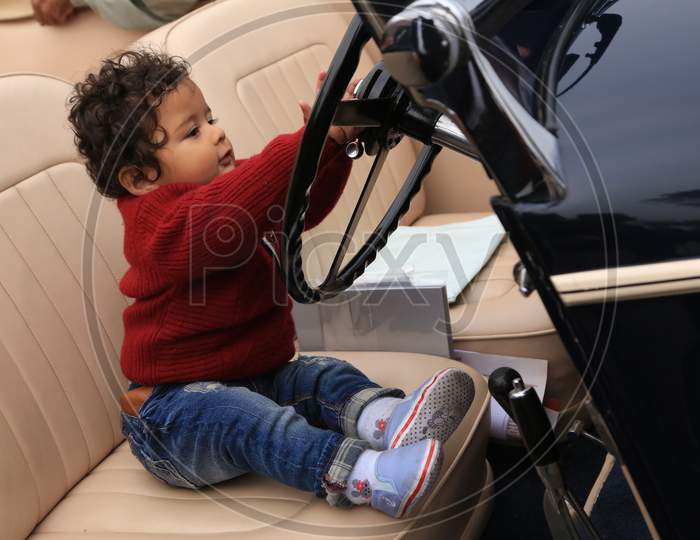 A Little kid holding the steering wheel