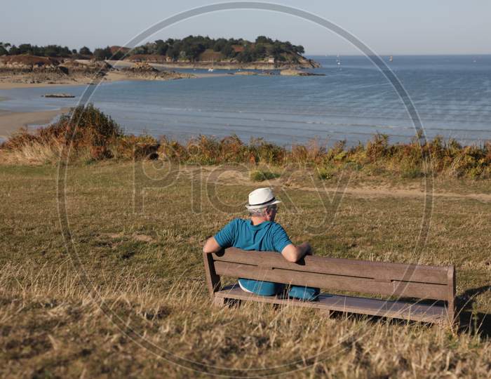 A Man enjoying the view sitting on the bench