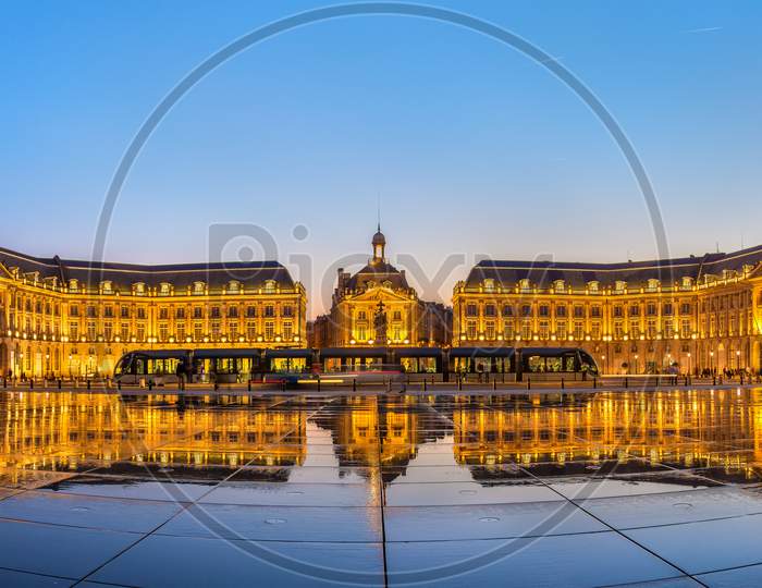 Iconic Panorama Of Place De La Bourse With Tram And Water Mirror Fountain In Bordeaux, France